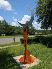 Metal sculpture of a crescent moon on a base with Big Dipper constellation cut-out pattern