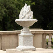 Ornate classical urn with sculpted flame motif on a square pedestal, featuring old world European and Renaissance design elements. Side View
