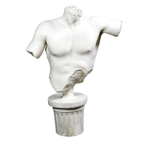 Classical Greek male torso sculpture with missing head and arms, displayed on an ornate fluted pedestal in old world European style.