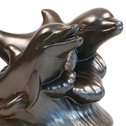 Two ornate dolphins leaping over stylized waves in a classical old world European sculptural design. Side View