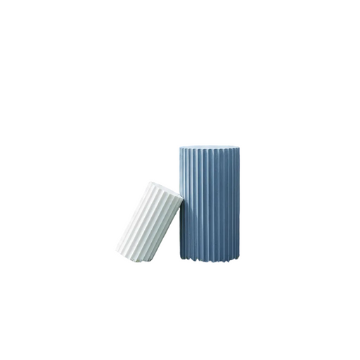 Fluted cylindrical vessels with classical Greek-inspired vertical ridges, one upright and one leaning beside it.