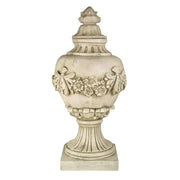 Ornate classical urn with Baroque floral garland, fluted pedestal base, and old world European decorative detailing.