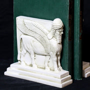 Sphinx-shaped ornate bookends with classical old world European detailing, supporting two upright hardcover books. Other Angle