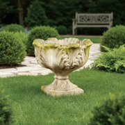 Ornate old world European urn planter with scalloped rim, classical leaf motifs, and pedestal base in a weathered finish. Side Angle