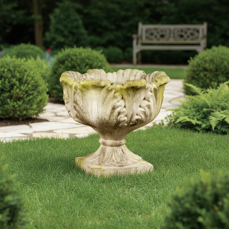 Ornate old world European urn planter with scalloped rim, classical leaf motifs, and pedestal base in a weathered finish. Side Angle