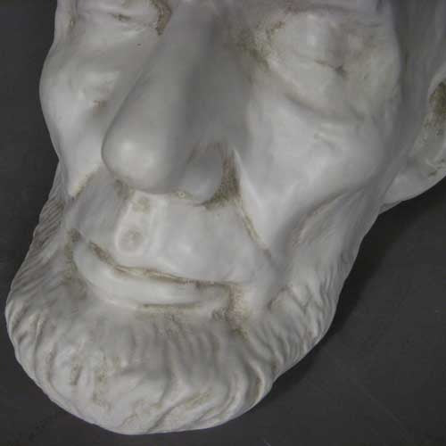 Classical old world European sculpted head with closed eyes, detailed facial features, and a prominent beard in Renaissance style. Side View