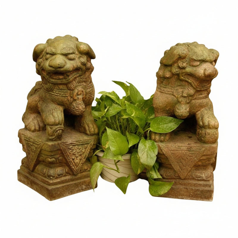 Pair of ornate, old world European lion statues with classical detailing, flanking a leafy plant in a decorative arrangement.