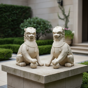 Pair of ornate, old world European lion statues with classical detailing, each resting a paw on a decorative sphere. Side Angle