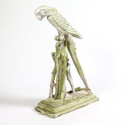 Ornate old world European parrot sculpture perched on a classical pedestal with intricate detailing and elegant, elongated form.
