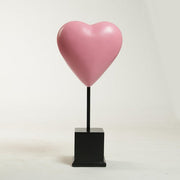 Heart-shaped sculpture on a square pedestal stand, featuring smooth, minimalist lines with a classical European influence. Side View