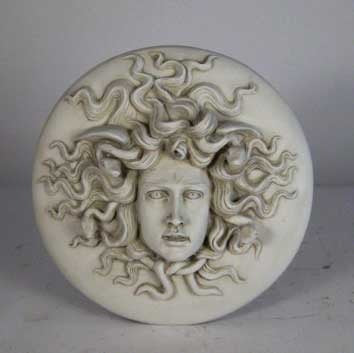 Medusa head relief with intricate serpentine hair, classical Greek style, ornate detailing, and dramatic facial expression. Side View