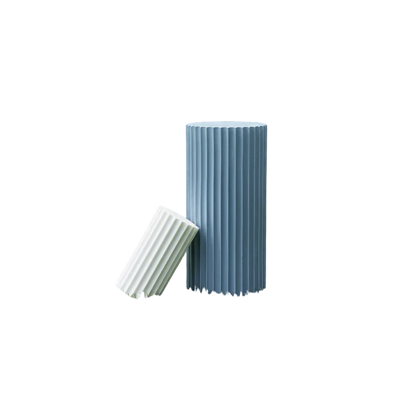 Fluted column-inspired candle set with classical Greek architectural style and vertical grooves, one upright and one tilted.