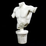Classical Greek male torso sculpture with missing head and arms, displayed on an ornate fluted pedestal in old world European style. Other Angle