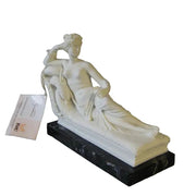 Reclining classical female figure in Greco-Roman style with ornate detailing, resting on a dark rectangular base.