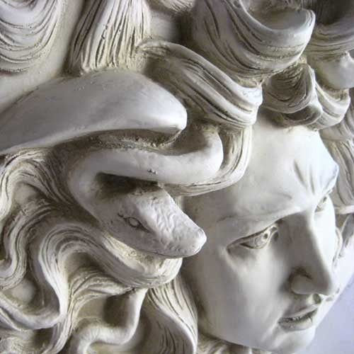 Medusa head relief with intricate serpentine hair, classical Greek style, ornate detailing, and dramatic facial expression. Other Angle