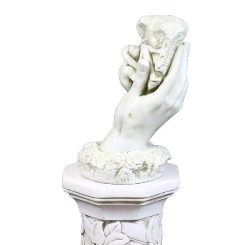 Classical sculpted hand emerging from ornate pedestal, holding a textured stone in old world European style