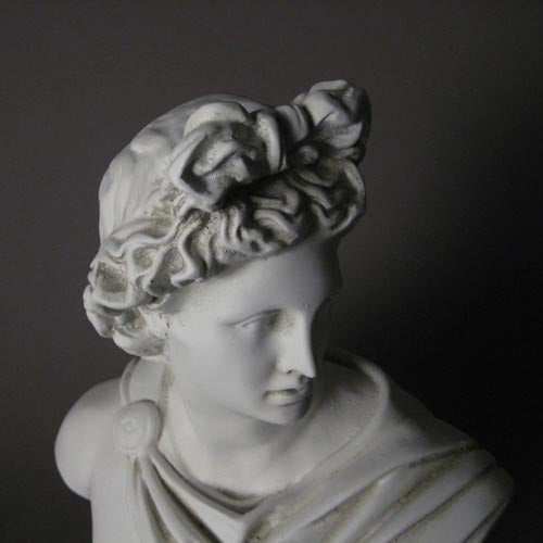 Classical Greek-style bust with ornate drapery and detailed hair, featuring a serene, idealized facial expression. Other Angle