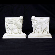 Sphinx-shaped ornate bookends with classical old world European detailing, supporting two upright hardcover books. Different Angle