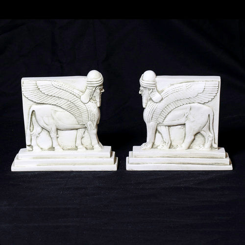 Sphinx-shaped ornate bookends with classical old world European detailing, supporting two upright hardcover books. Different Angle