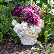 Ornate Baroque-style planter featuring sculpted cherub faces and classical old world European detailing around the rim. Side Angle