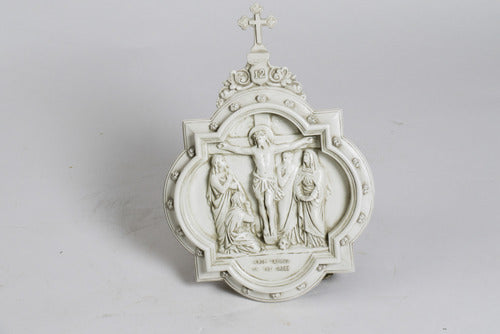 Crucifixion relief in ornate old world European style with classical figures and decorative Baroque frame topped with a cross.