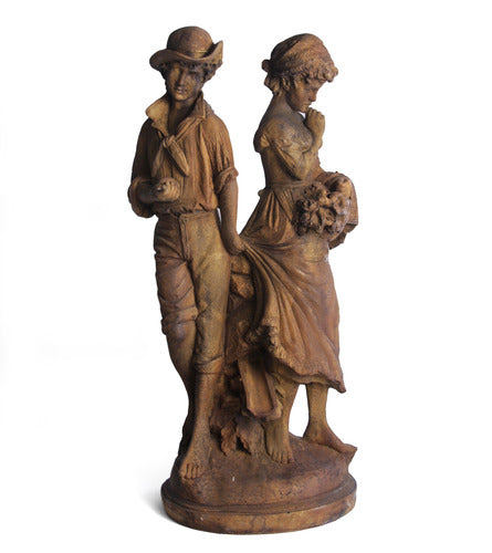 Baroque-style sculpture of a young man and woman in classical attire, standing together with ornate detailing and old world European charm.