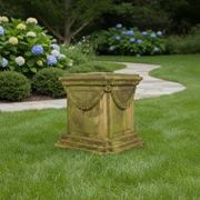 Ornate square pedestal with classical old world European design, featuring garland relief and weathered, mossy Baroque detailing. Side Angle