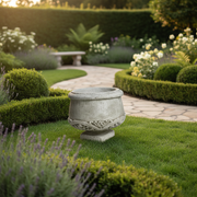 Ornate old world European planter with classical carved scrollwork and pedestal base, featuring a rounded bowl shape. Side Angle
