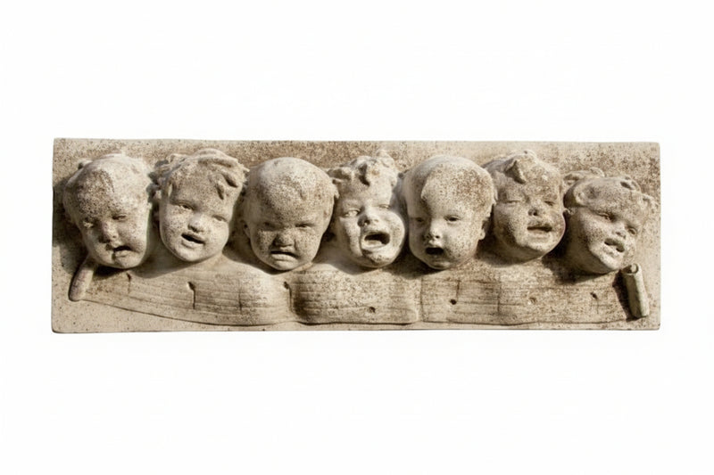 Baroque-style sculpted relief of seven cherubic faces with expressive features in an ornate, old world European design.