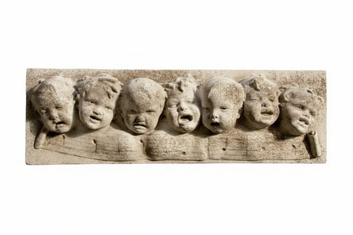 Baroque-style sculpted relief of seven cherubic faces with expressive features in an ornate, old world European design.