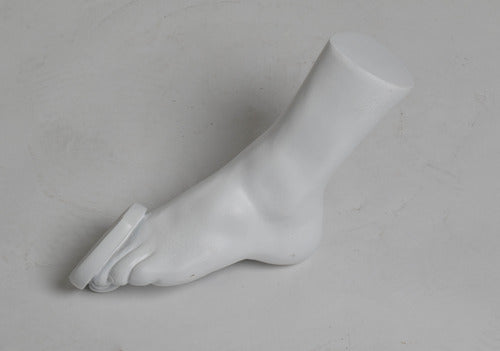 Classical Greek-style sculpted foot with detailed toes and smooth, minimalist form, reminiscent of ancient statuary.