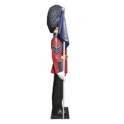 British royal guard statue in ornate old world European style uniform, tall bearskin hat, holding a flag, classical military theme Additional Angle