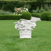 Corinthian column capital with ornate acanthus leaves, scrolls, and classical floral motifs in old world European style. Side Angle