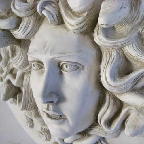 Medusa head relief with intricate serpentine hair, classical Greek style, ornate detailing, and dramatic facial expression. Different Angle