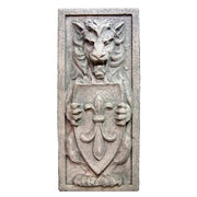 Lion relief sculpture in old world European style, holding a fleur-de-lis shield with ornate medieval and Gothic detailing.