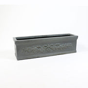 Rectangular planter box with ornate classical relief featuring a bow and garland motif in an old world European style.