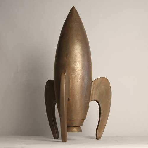 Rocket sculpture with smooth, streamlined form and three curved legs, featuring a minimalist, old world European retro-futuristic style. Side View