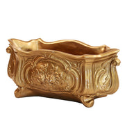Ornate Baroque planter with intricate floral relief and curved, classical old world European design elements.