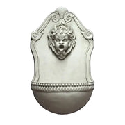 Wall fountain with ornate Baroque design, featuring a classical cherub face and decorative scrollwork in old world European style.