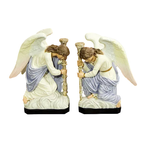 Pair of kneeling angels with serene facial expressions holding tall ornate candlesticks on cloud-like bases.
