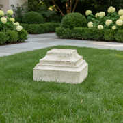 Classical pedestal base with stepped, tiered design and weathered old world European architectural style. Side Angle