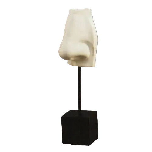 Classical Greek-style sculpted nose fragment on a pedestal stand, featuring smooth, minimalist lines and an old world European aesthetic.