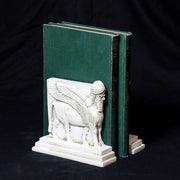 Sphinx-shaped ornate bookends with classical old world European detailing, supporting two upright hardcover books. Side View