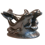 Two ornate dolphins leaping over stylized waves in a classical old world European sculptural design.
