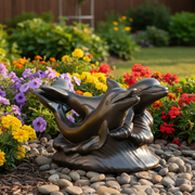 Two ornate dolphins leaping over stylized waves in a classical old world European sculptural design. Side Angle