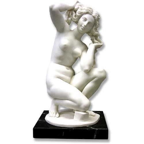 Kneeling female nude statue in classical Renaissance style with flowing hair, ornate detailing, and graceful pose on a pedestal.