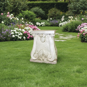 Ornate pedestal with classical scrollwork, textured surface, and old world European Baroque-inspired decorative details. Side Angle