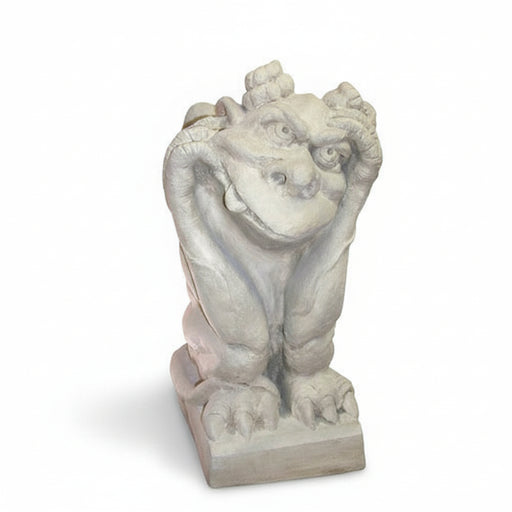 Gothic-style gargoyle statue with a whimsical expression, crouching on a pedestal with hands framing its face.