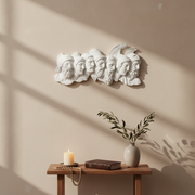 Greek classical relief sculpture featuring seven ornate male profiles with detailed helmets and beards in an old world European style. Side Angle