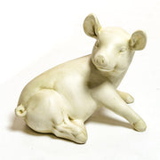 Seated pig figurine with gentle expression, sculpted in an old world European classical style with smooth, ornate detailing.